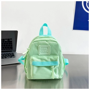 Détail de la poche avant et du logo Girl Cats sur le sac à dos d'école vert menthe