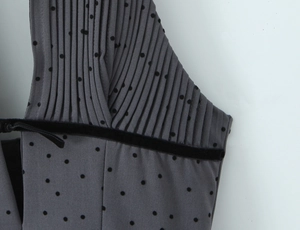 Detail of grey pleated neckline with black flocking dots and elegant velvet strap trim