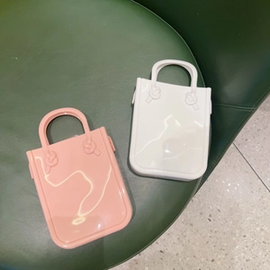 Detailed view of pink and white PVC jelly bags on a green stool and terrazzo floor