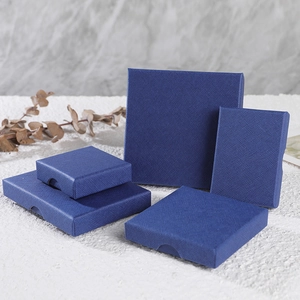 Dark blue textured jewelry gift boxes in various sizes displayed on a white marble surface