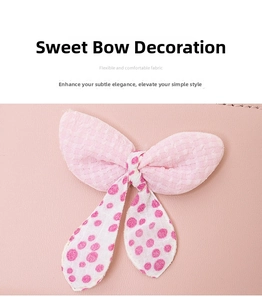 Detailed macro view of a pink bow made of plaid and polka dot fabric on leather wallet
