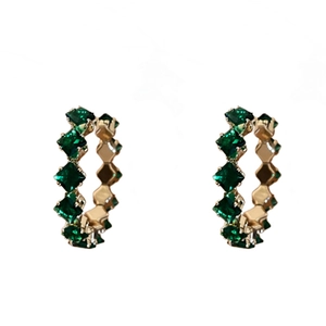 Gold C-shaped hoop earrings with emerald square rhinestones on a white background