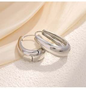 Macro detail of silver-tone teardrop hoop earrings with high-polished mirror finish