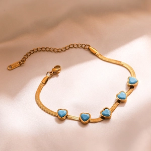Vergoldetes Schlangenarmband aus Edelstahl mit fünf blauen Herzanhängern auf Seide