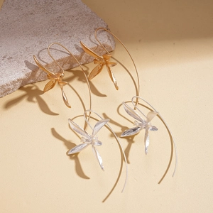 Metallic iris flower hook earrings in gold and silver finishes on a stone display