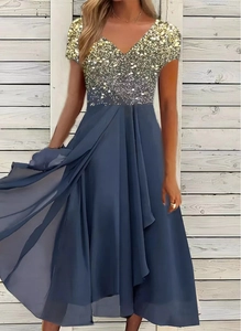 Detail of dark blue chiffon dress with gold and silver gradient sequins and elegant V-neckline