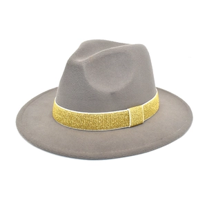 Detail of dark grey wool fedora featuring a shiny gold glitter band with white trim edge