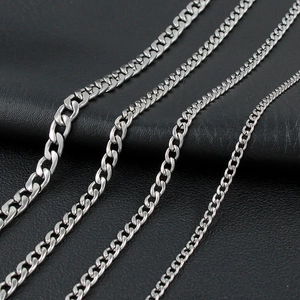 Detail of four different widths of silver stainless steel Cuban link chains on black leather
