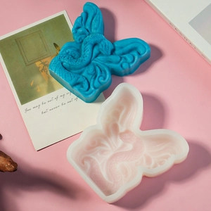 Vista macro dello stampo in silicone con un pezzo finito blu a scaglie di drago in rilievo