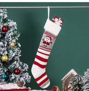 Knitted Christmas stocking with Santa Claus pattern hanging in festive holiday setting