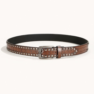 Gros plan détaillé d'une ceinture en cuir style punk vintage marron avec clous.