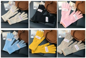 Flat lay of knit touchscreen gloves in beige, black, pink, blue, yellow, and khaki colors