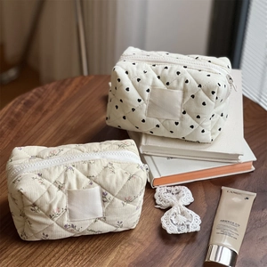 Detailed close-up of quilted corduroy makeup bags with heart and floral patterns