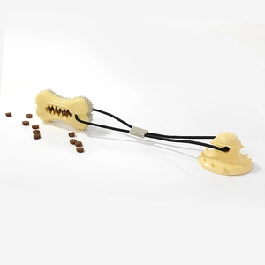 Self-playing dog toy with suction cup and squeaky treat-dispensing bone-shaped chew ball