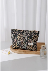 Detail of black floral vanity bag with textured jacquard fabric and H&R BAG woven label