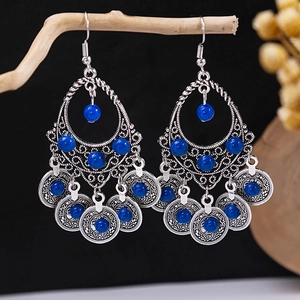 Detailed shot of Bohemian silver drop earrings with turquoise beads on a natural background