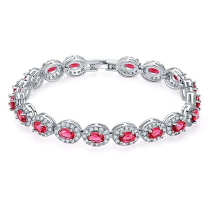 Detail of silver link bracelet with oval red halo gemstones and crystal accents