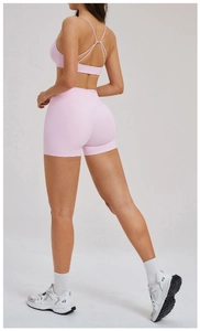 Rear view of pink sports bra with cross back straps and high waist yoga shorts
