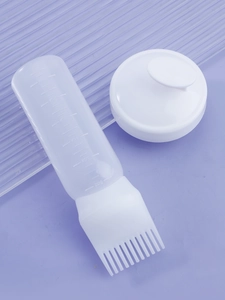 Hair dye bottle with applicator comb showing milliliter and ounce measurement scales