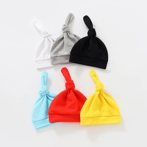 Set of newborn baby knotted hats in six solid colors made of soft ribbed cotton fabric