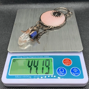 Macro shot of retro sun god pendant weighing 44.19g on a digital scale for size guide