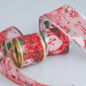 Vue détaillée de rubans de Noël rouges et roses avec motifs Père Noël et bordures dorées