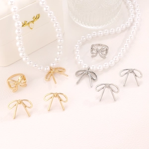 Elegant bow jewelry set with faux pearls including necklace, ring and earrings