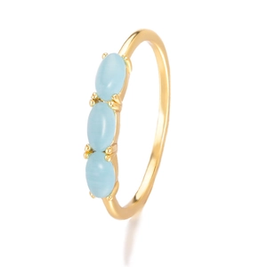 Detail of gold-plated ring set with three oval blue cat-eye stones in vertical row