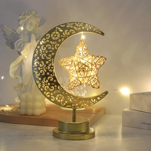 Primer plano detallado de la lámpara de mesa metálica con diseño de luna y estrella de mimbre.