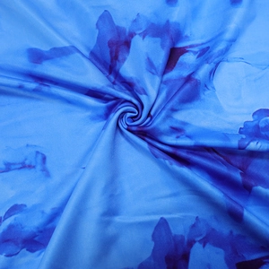 Detail of blue tie-dye printed dress fabric showing smooth texture and elastic material