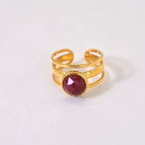 Detailed macro view of gold-plated ring with 10mm round red gemstone inlay and three-band design