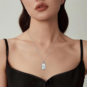 Silver woven mesh necklace with white rectangular gemstone pendant worn by a model