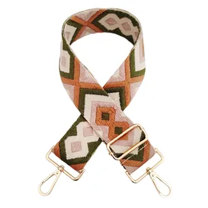 Detail of pink brown and green diamond pattern embroidered bag strap with gold buckle