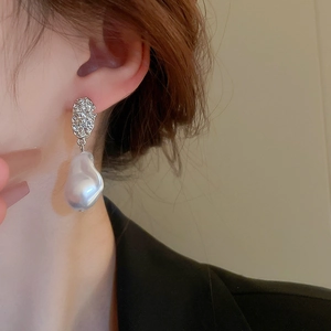 Detailed model shot showing the irregular silver metal and baroque pearl earring
