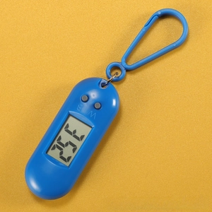 Blue portable digital thermometer with carabiner hook showing LCD display on yellow background