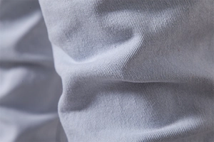 Close-up of light blue washed denim fabric showing twill weave and soft texture