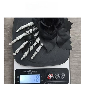 Detailed view of the 18g lightweight Halloween skeleton hand and black rose hair clip