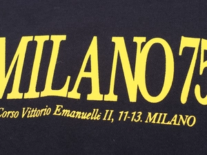 Detail of yellow Milano 7 printed text on black cotton sweatshirt fabric texture