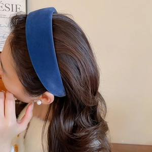 Close-up of deep blue velvet wide headband showing soft texture on wavy brown hair