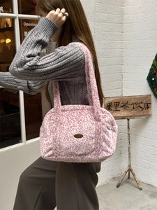 Détail du sac cabas en fausse fourrure léopard rose avec emblème doré en métal