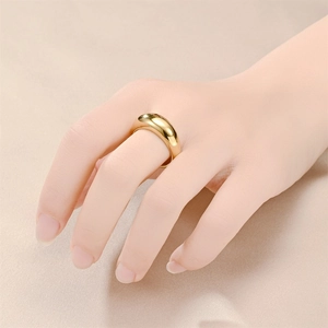 Close-up of golden wide dome ring in polished titanium steel on model finger