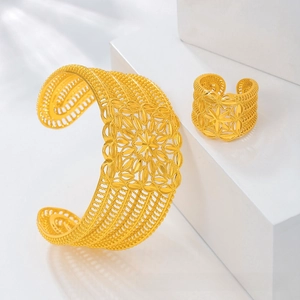Detailed view of ornate gold-plated hollow filigree bridal bracelet and ring set