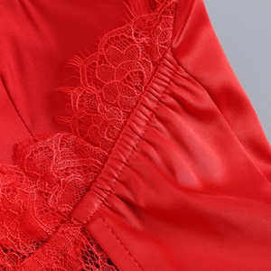 Vue détaillée du satin rouge avec dentelle délicate et détails de coutures plissées