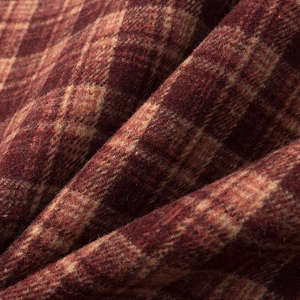 Close-up of wine red and sand brown plaid tweed fabric with detailed woven texture