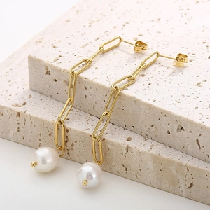 Vue détaillée des boucles d'oreilles chaînettes dorées avec perles blanches élégantes