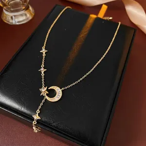 Elegant gold zircon necklace with crescent moon and star pendant on a black gift box
