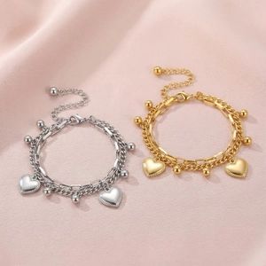 Detail of double-layered stainless steel heart bracelet in gold and silver finish