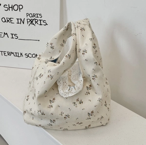 Detail of floral corduroy handbag with delicate white lace trim and blue flower patterns