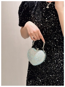 Close-up of heart-shaped evening bag with iridescent rhinestones and silver metal handle