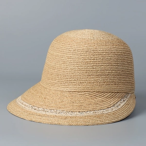 Detail of raffia sun hat with elegant woven texture and white crochet lace trim ribbon
